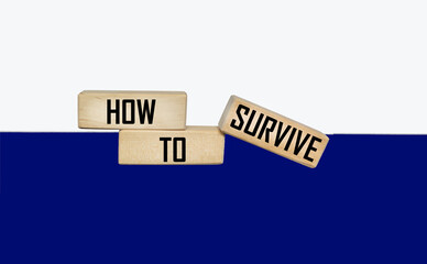 How to Survive words on wooden blocks. The concept of survival of a business startup. The concept of coronavirus prevention in the healthcare sector.