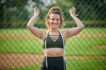 Gorgeous young female fitness model poses outdoors with jump rope