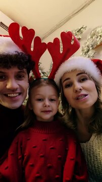 Family in Christmas hats makes a video call, sharing warm holiday wishes