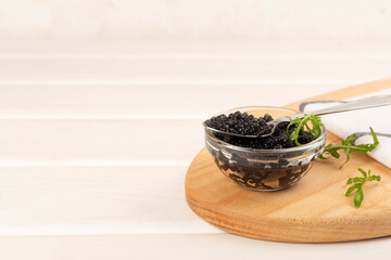 Jar with black caviar on on wooden table