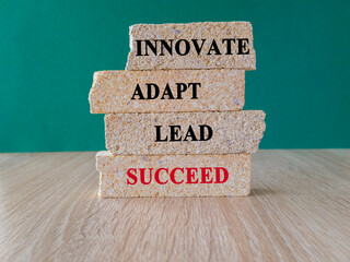 Innovate adapt lead succeed symbol. Concept words Innovate Adapt Lead Succeed on beautiful brick...