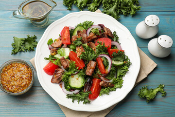 Delicious fresh tuna salad and ingredients on light blue wooden table, flat lay