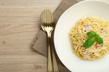 Delicious pasta Carbonara served on wooden table, flat lay