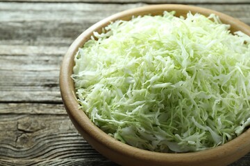 Fresh shredded cabbage on wooden table, closeup