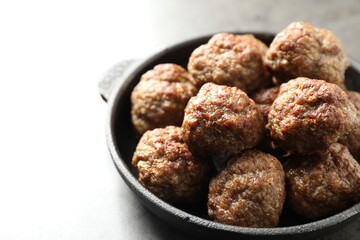 Tasty meatballs in baking dish on grey table, closeup. Space for text