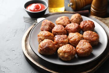 Tasty cooked meatballs served on grey table