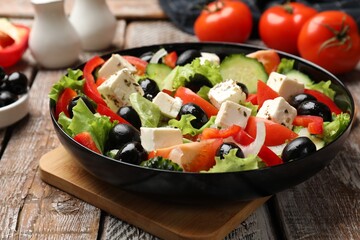 Delicious fresh Greek salad on wooden table, closeup