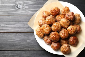 Many delicious meatballs on dark wooden table, top view. Space for text