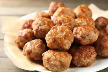 Many delicious meatballs on wooden table, closeup