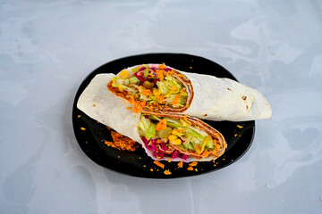 Cig kofte (raw meatball) with lettuce, tomato, pickle and lemon, hot Chee kofta. Turkish local raw food concept.Table scene of assorted take out or delivery foods. Doritoslu duble cig kofte durum.