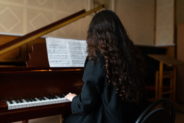 Pianist with Sheet Music Playing a Grand Piano in Studio