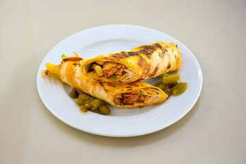 Lavash doner kebab ( soslu kasarli zurna doner durum )  or shawarma sliced in plate isolated.  Tavuk Et Doner Durum. Hatay Iskenderun usulu bazuka tavuk doner durum.