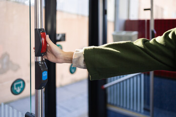 Woman in Green Coat Pressing Bus Stop Button