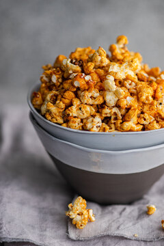 Cozy bowl of caramel popcorn on a textured background