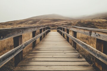 Obraz premium A wooden bridge spans a wide, empty field