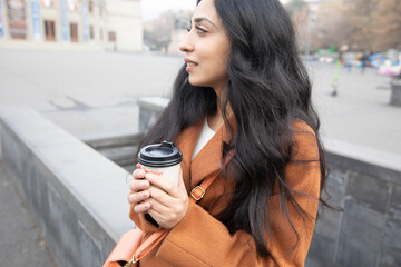 woman with coffee cup in city street