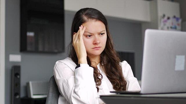 Thoughtful tired woman working on laptop computer looking on screen thinking solving problem at home office, serious woman search for inspiration make decision feel lack of ideas