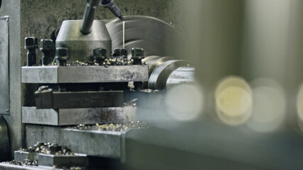 Close up of industrial lathe machine cutting metal part, lubricating and producing swarf, showcasing precision and efficiency in metalworking process
