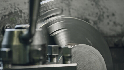 Close up of metal processing on an industrial lathe, shaping a cylindrical part with high precision and speed, showcasing the manufacturing process in a factory setting