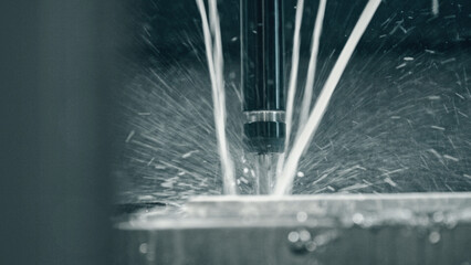 Close up of industrial metalworking cutting process of cnc milling machine using coolant and lubrication, showing high precision and advanced technology in modern manufacturing