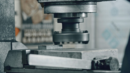 Close up of a powerful industrial stamping machine pressing a metal workpiece, showcasing the...