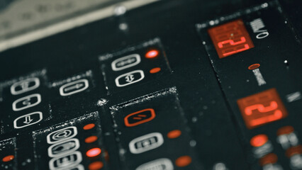Close up view of a control panel displaying temperature readings and various settings, with red lights illuminating specific buttons, indicating active functions or selected options