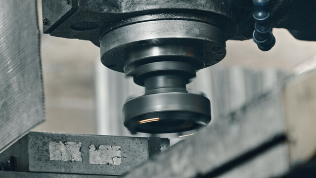 Close up of a milling machine cutting a metal part, creating sparks and demonstrating the precision and power of modern manufacturing processes in a factory setting