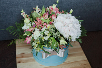 A bouquet of flowers in a box with hydrangea, alstroemeria, poppy, eustoma and greenery