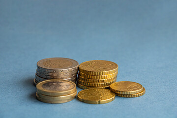 Stack of coins lying on table on blue background
