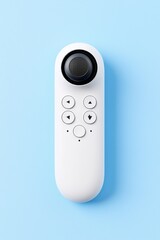 A white remote control is positioned on a blue-gray surface.