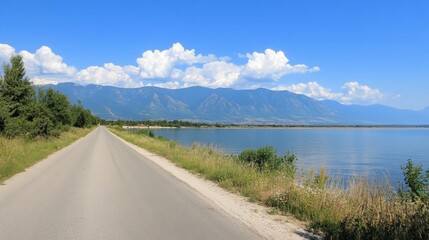 Serene Road Along the Tranquil Lake with Scenic Mountain Backdrop