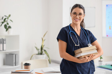 Young female medical student with books and stethoscope in clinic