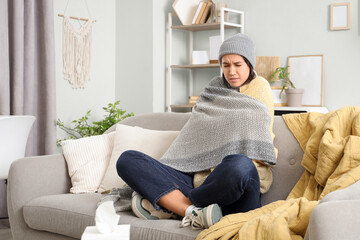 Fototapeta premium Sick young woman sitting on sofa
