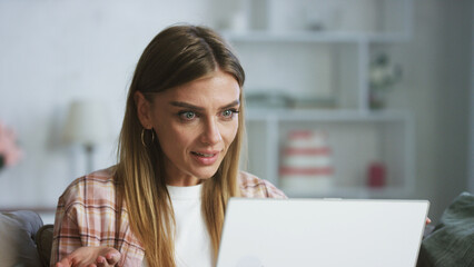 Young shocked freelancer woman working from home office using laptop having video call with client or colleagues feeling surprised by information she received