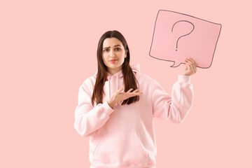 Young woman holding speech bubble with question mark on pink background