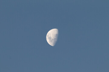 la luna visible durante el día, un cielo azul y la luna blanca