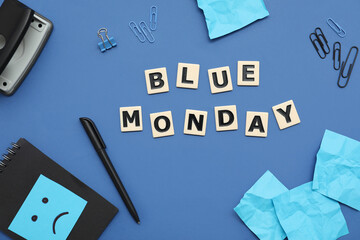 Office stationery with drawn sad face and text BLUE MONDAY