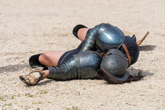 A defeated gladiator falling to the ground
