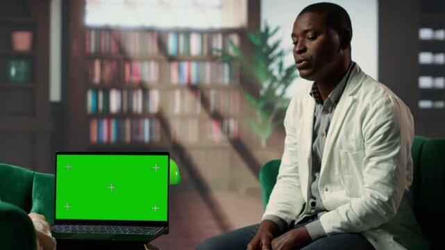 Young male medic feels powerless in counseling next to mockup, experiencing PTSD and grief when losing patients due to complications. Doctor opening up about career nightmares. Camera B.