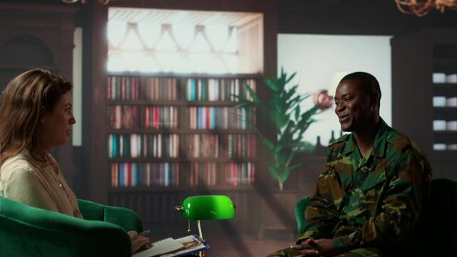 Black military officer in army uniform attends counseling session, looking distressed and opening up about post traumatic combat stress. War soldier dealing with shell shock. Camera B.