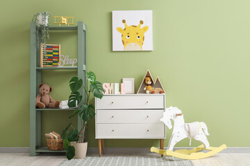Interior of nursery with commode, shelf unit and toys