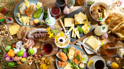 A colorful and inviting brunch spread features an assortment of cheeses, breads, and decorative Easter elements, creating a vibrant and festive dining experience.