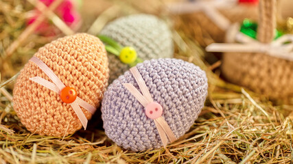 This image features three intricately crocheted Easter eggs, each subtly decorated with ribbon and...