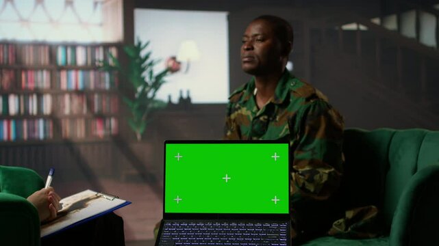 Army veteran at counseling shares war related anxiety next to isolated screen, discuss about psychological issues and infantry shell shock syndrome. Trooper listens to professional advice. Camera A.
