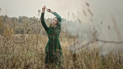 Fashion model posing in a field of dry grass