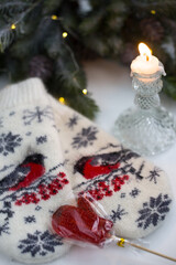 Women's woolen mittens with a mug of hot drink and marshmallows. Winter