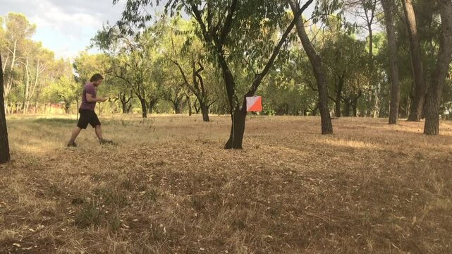 Orienteering athlete locating checkpoint in a woodland race