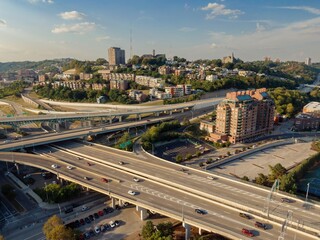 High-angle view of a city highway interchange, cars traversing the elevated roadways, and...