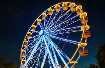 Large illuminated ferris wheel at night. Colorful lights. Big attraction at amusement park. Bright yellow cabins. Night fun. People probably enjoy ride. Dark sky background. Exciting amusement park