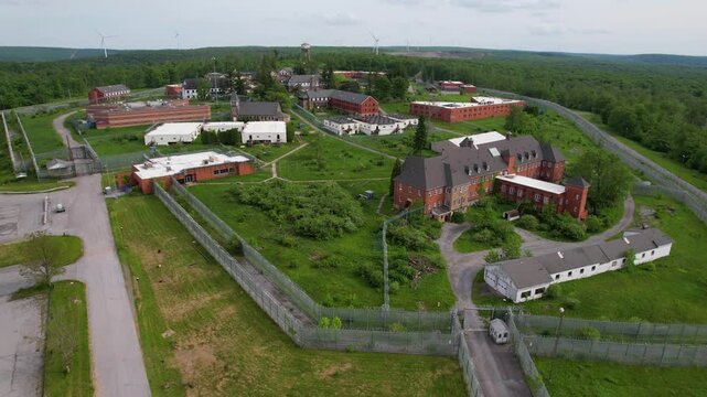 PENNSYLVANIA - 7.11.2024 - Great aerial footage begins circling counterclockwise around an abandoned sanitarium and prison in rural Pennsylvania.